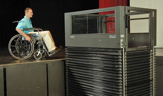 Man using Ascension Virtuoso vertical wheelchair lift to exit a stage