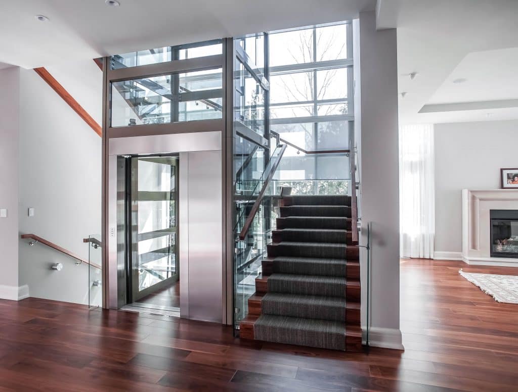 Glass elevator built into landing onto a luxury living area