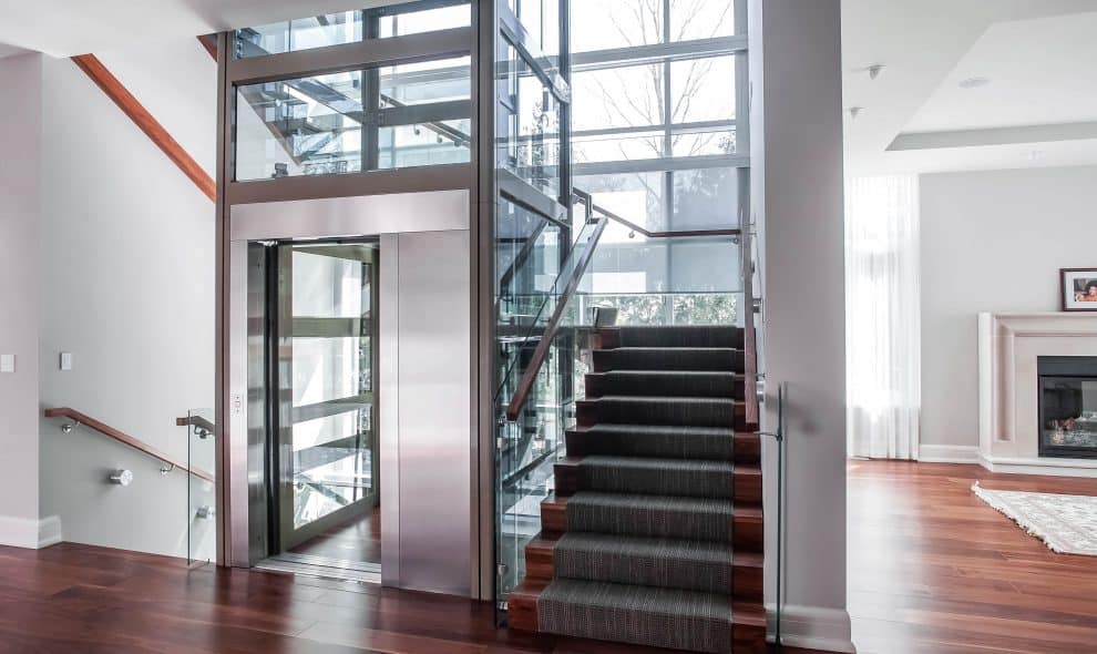 Glass elevator built into landing onto a luxury living area