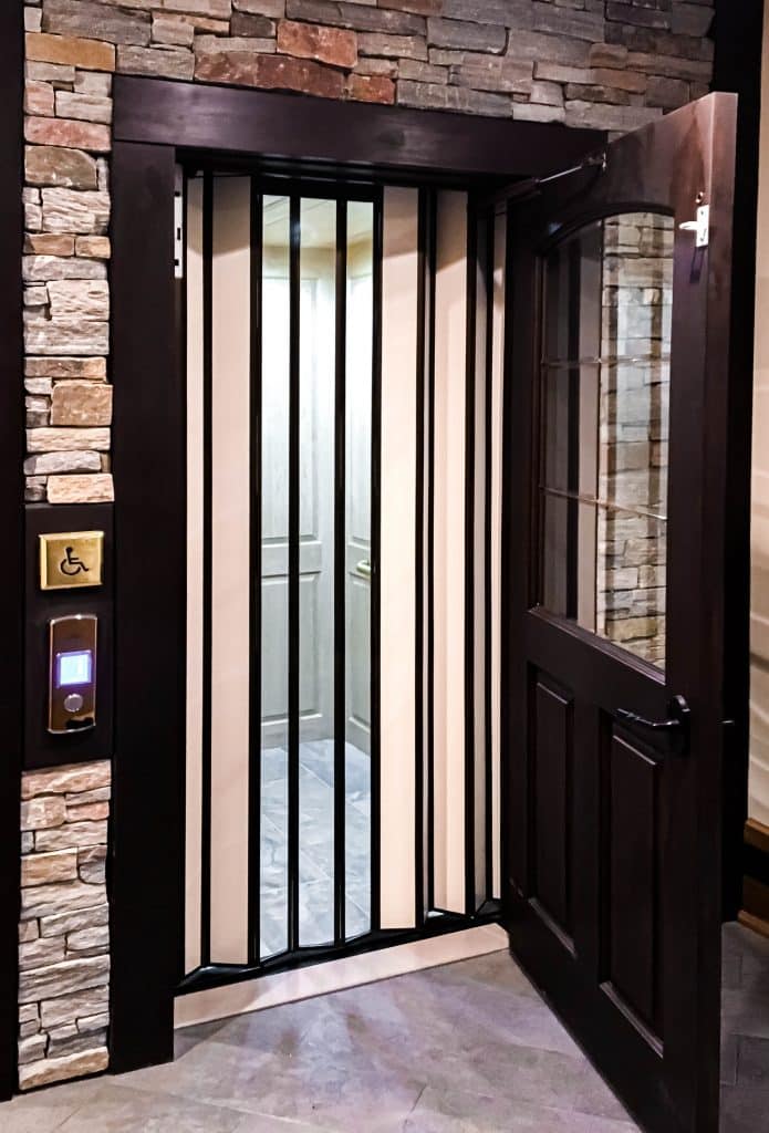 bifold glass elevator with stone surround