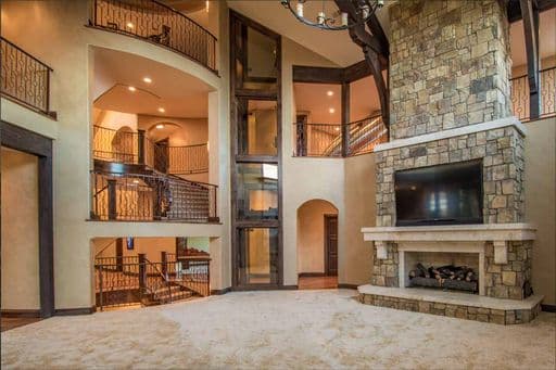 Glass elevator in large main living area of luxury home