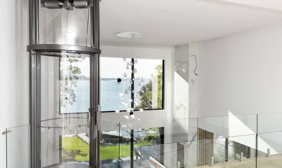 Circular glass elevator opening onto second story landing